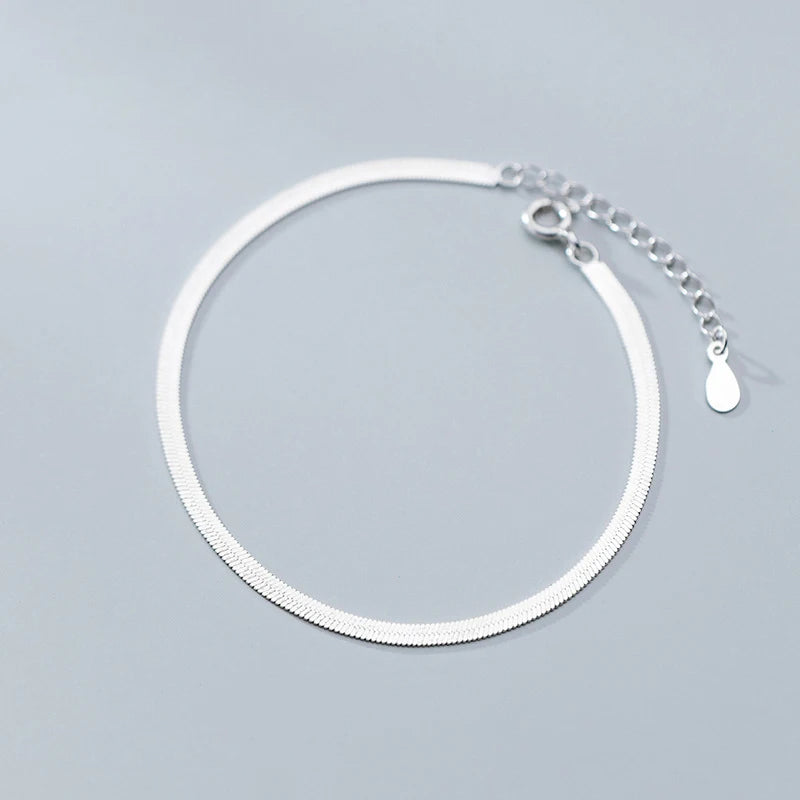 925 sterling silver bracelet charm beside a slim bracelet chain