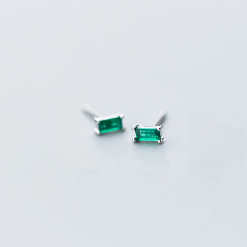 Silver stud earrings showing a refined emerald green center