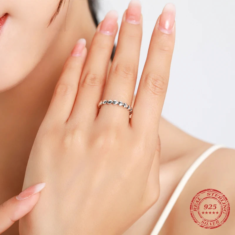 Silver ring with heart to heart motif styled as a stackable ring