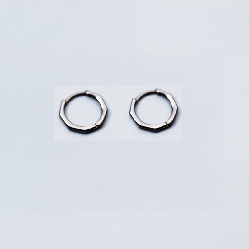 Close view of ear rings showcasing hoop earrings in silver