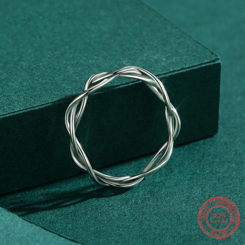 Side angle of sterling silver ring displaying smooth braided contours