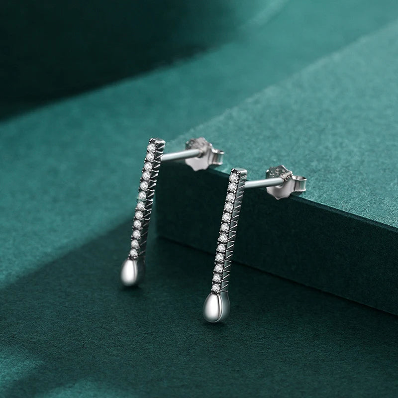 Pair of stud earrings arranged beside silver hoops for easy styling