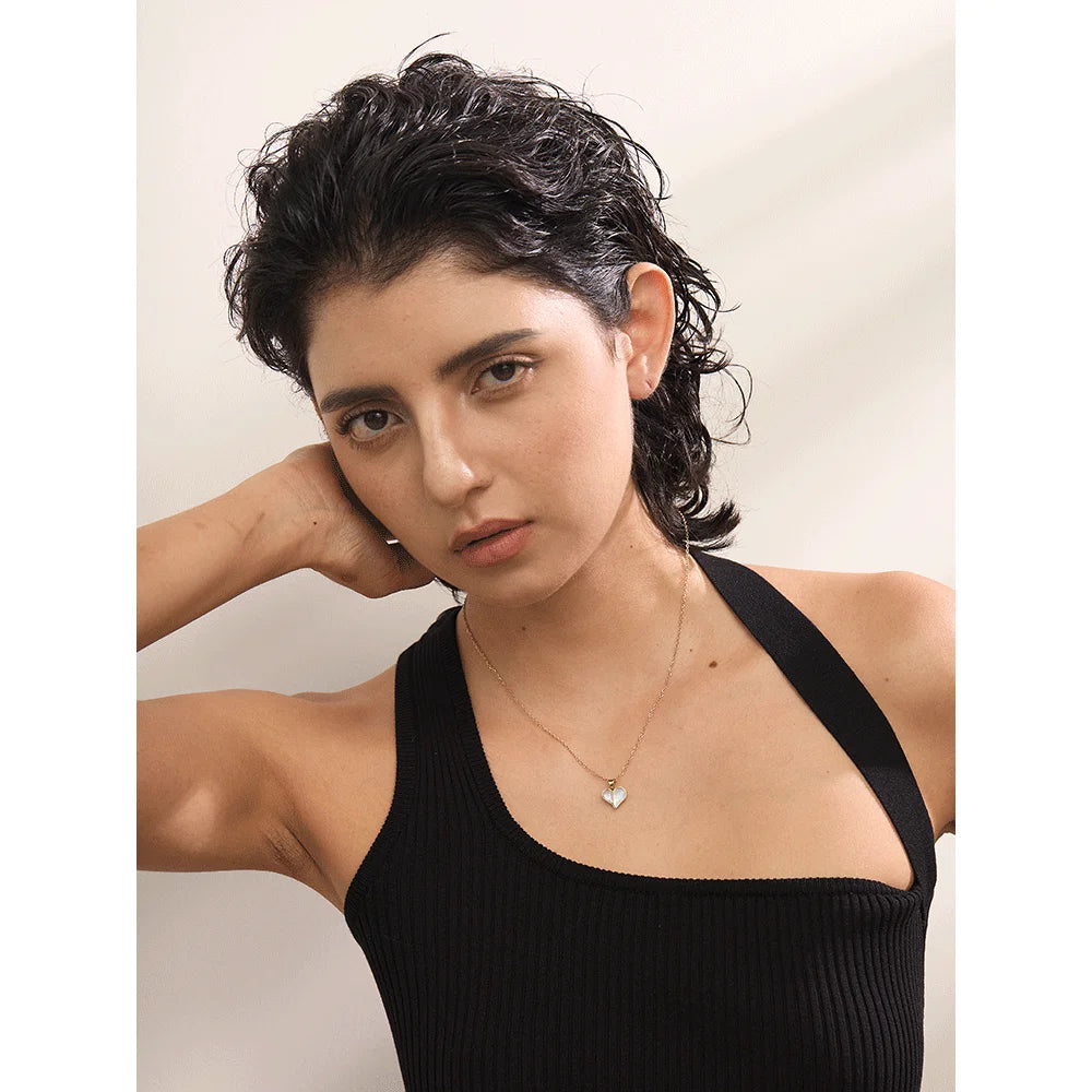 Close view of pendant necklace featuring a polished gold heart