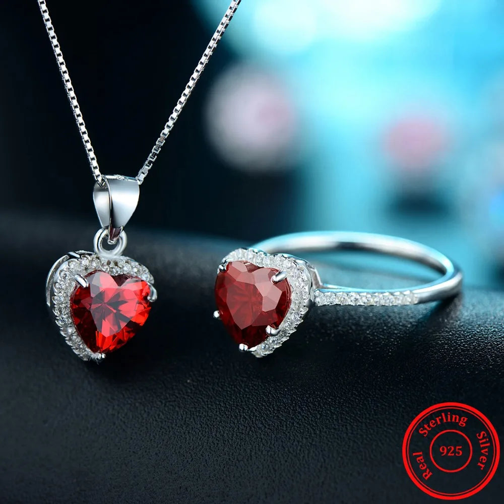Heart necklace with Red Heart charm beside a sterling silver ring