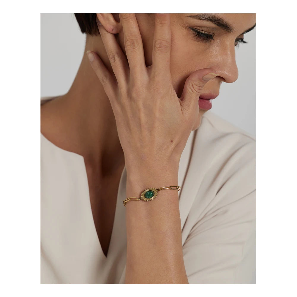 Close up of turquoise jewelry details on a gold plated chain bracelet