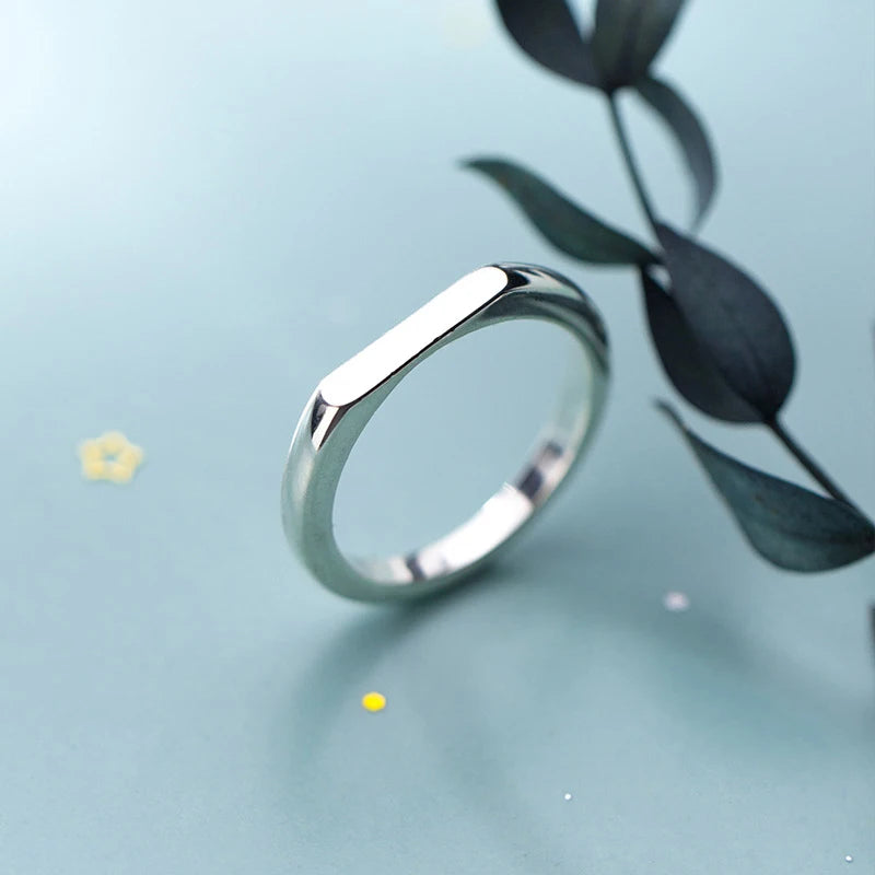 Minimal flatlay of sterling silver beside a ring with size note