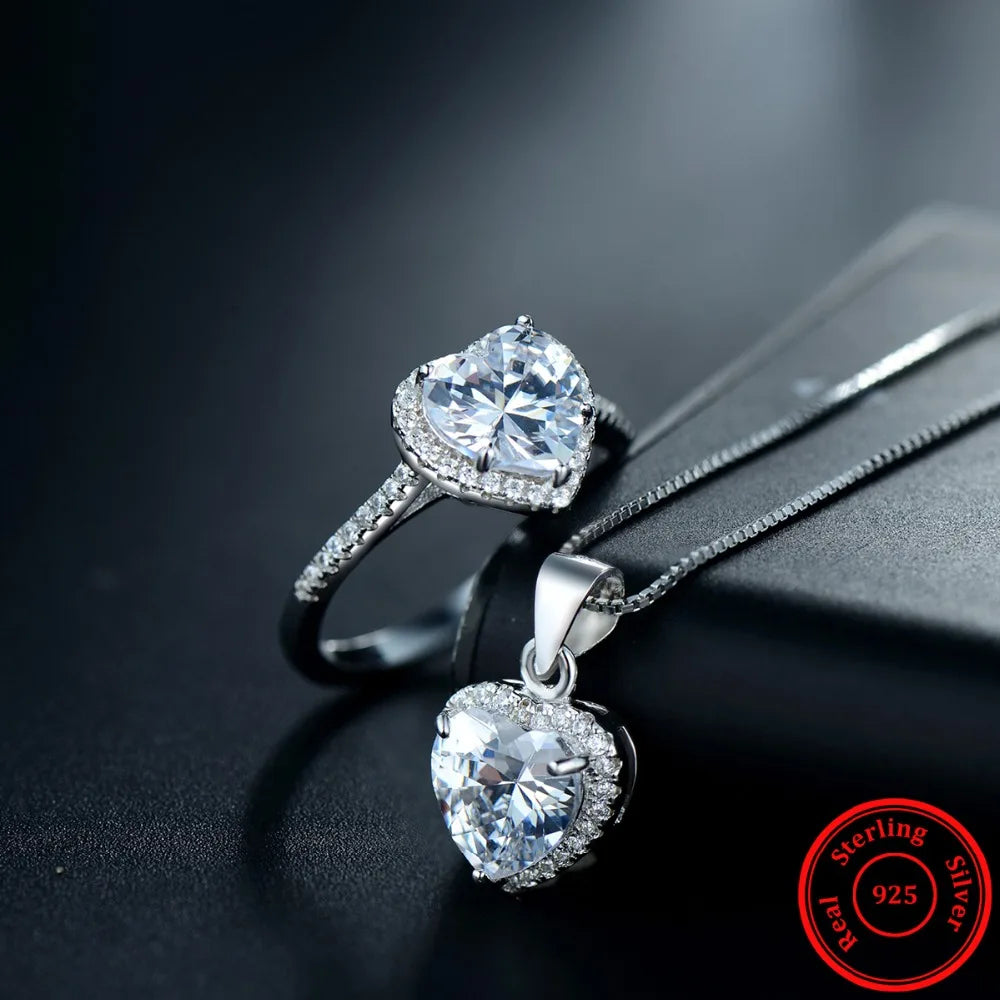 Elegant sterling silver ring beside a silver heart pendant necklace