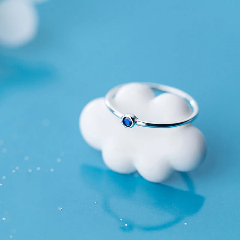 Close view of sterling silver ring featuring a bright blue crystal center