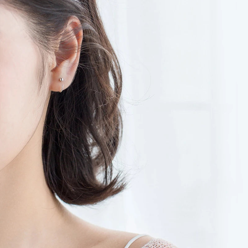 Minimal shot of silver hoop earrings arranged for ear rings styling