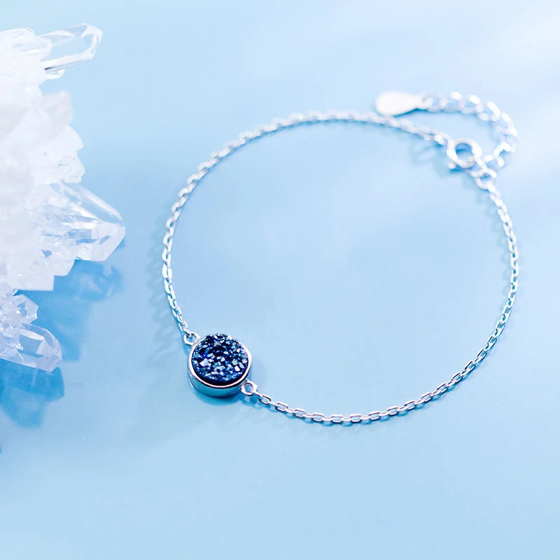 Crystal bracelet showing blue crystal facets beside a sleek silver bangle feel