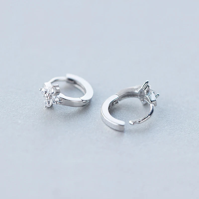 Sterling silver earrings featuring a delicate cz flower on silver hoop