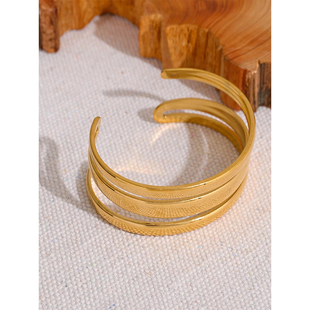 Minimal flat lay of a gold bracelet with bangle and bangle presence