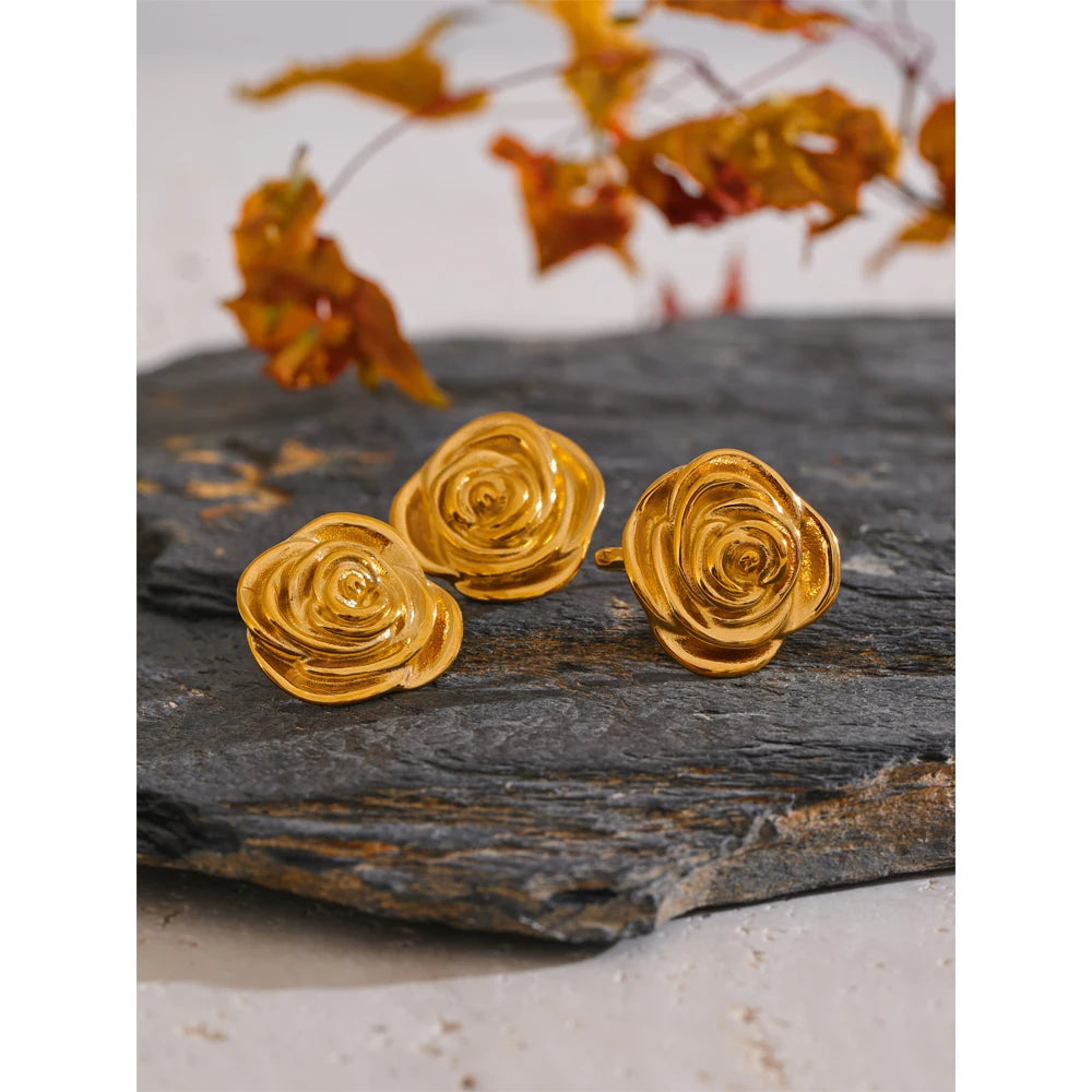 Minimal flatlay of gold plated flower earrings beside a matching gold ring