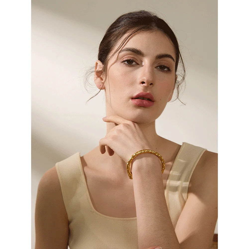 Close view of gold cuff bracelet detailing on a cuff bracelet in gold