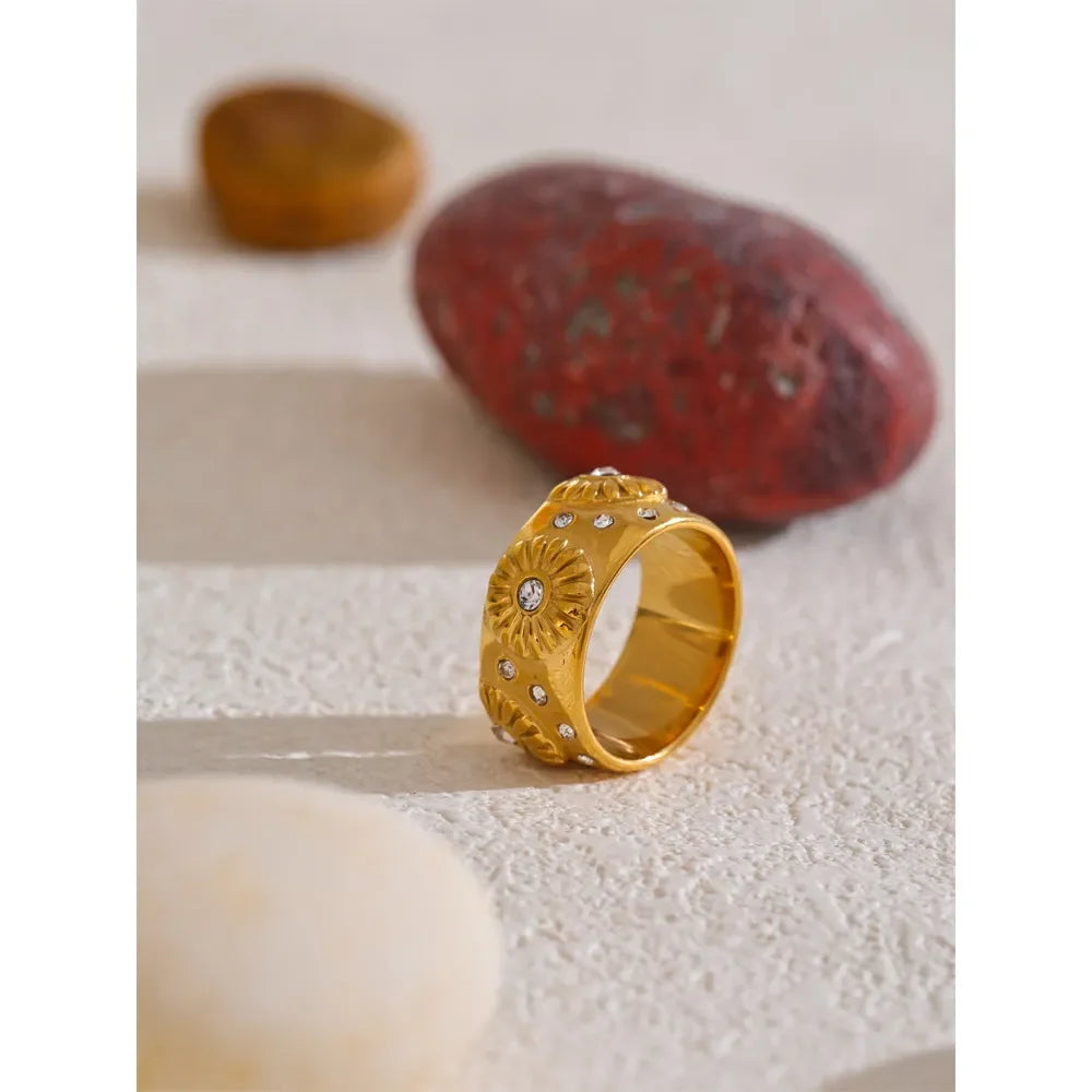 Gold jewelry trio daisy earrings bracelet ring on display