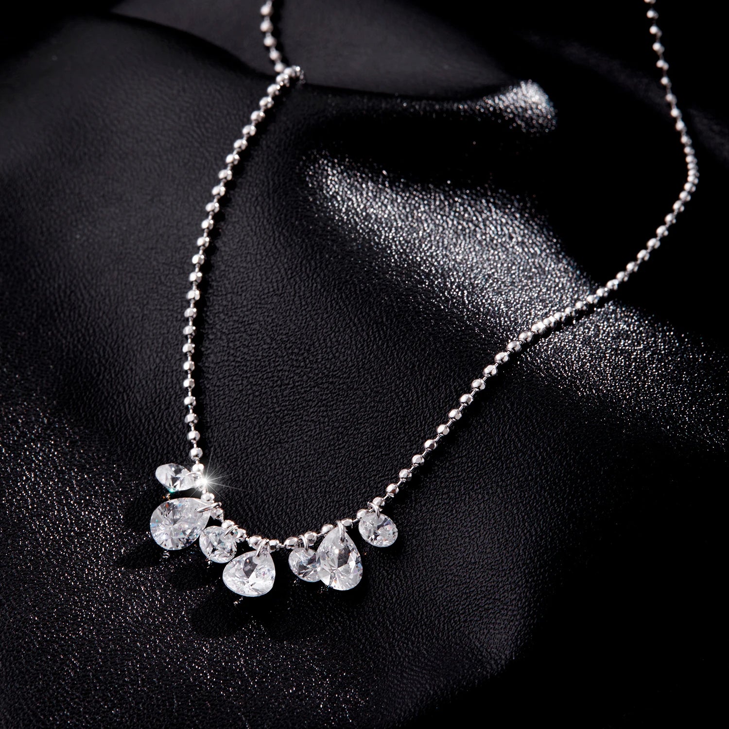 Pendant necklace adorned with pear cut cz and silver beads