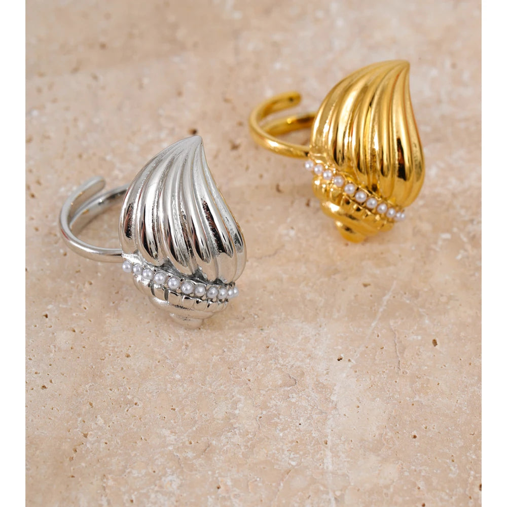 Soft light image of necklace gold necklace stack featuring a conch charm necklace