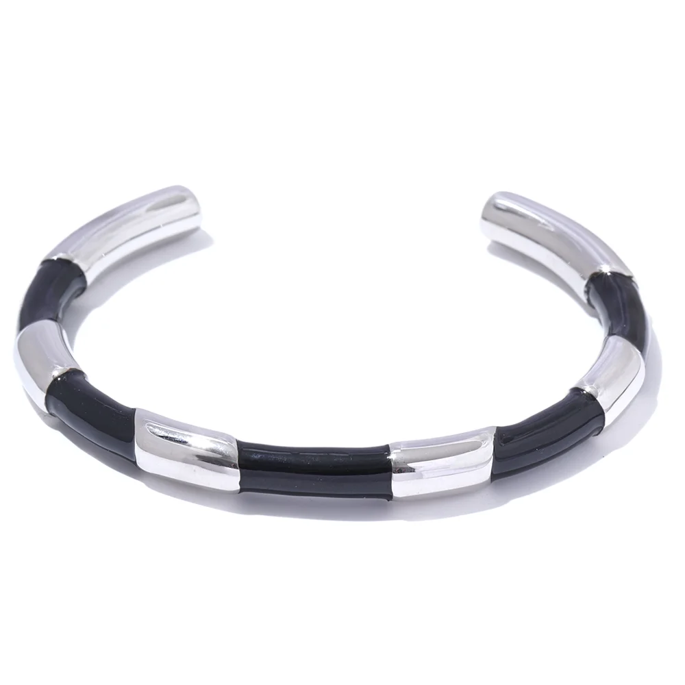 Gold-plated stainless steel open cuff bracelet with black and white enamel stripes.