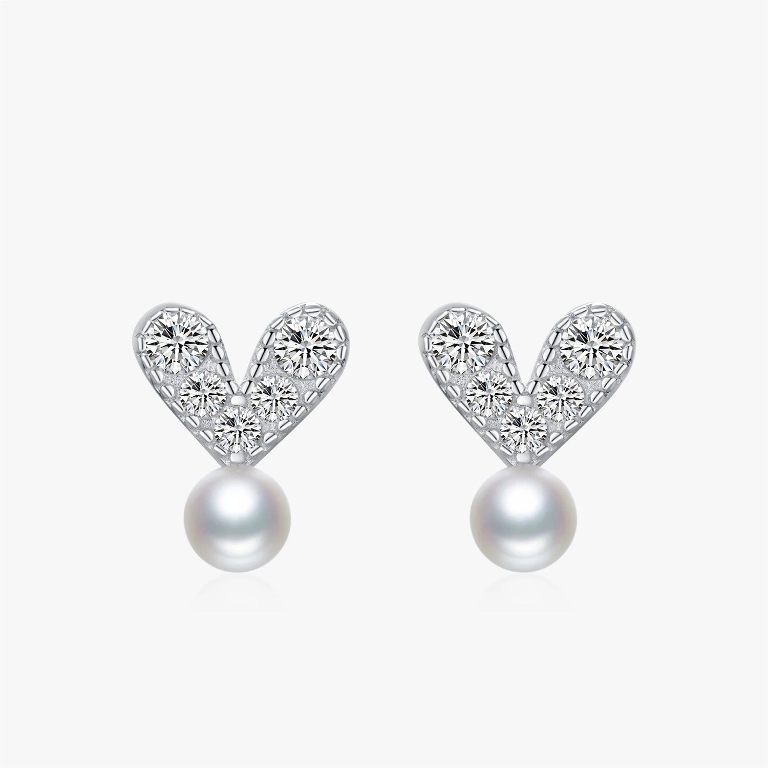 Pair of silver stud earrings displayed with pearl earrings and heart shape detail