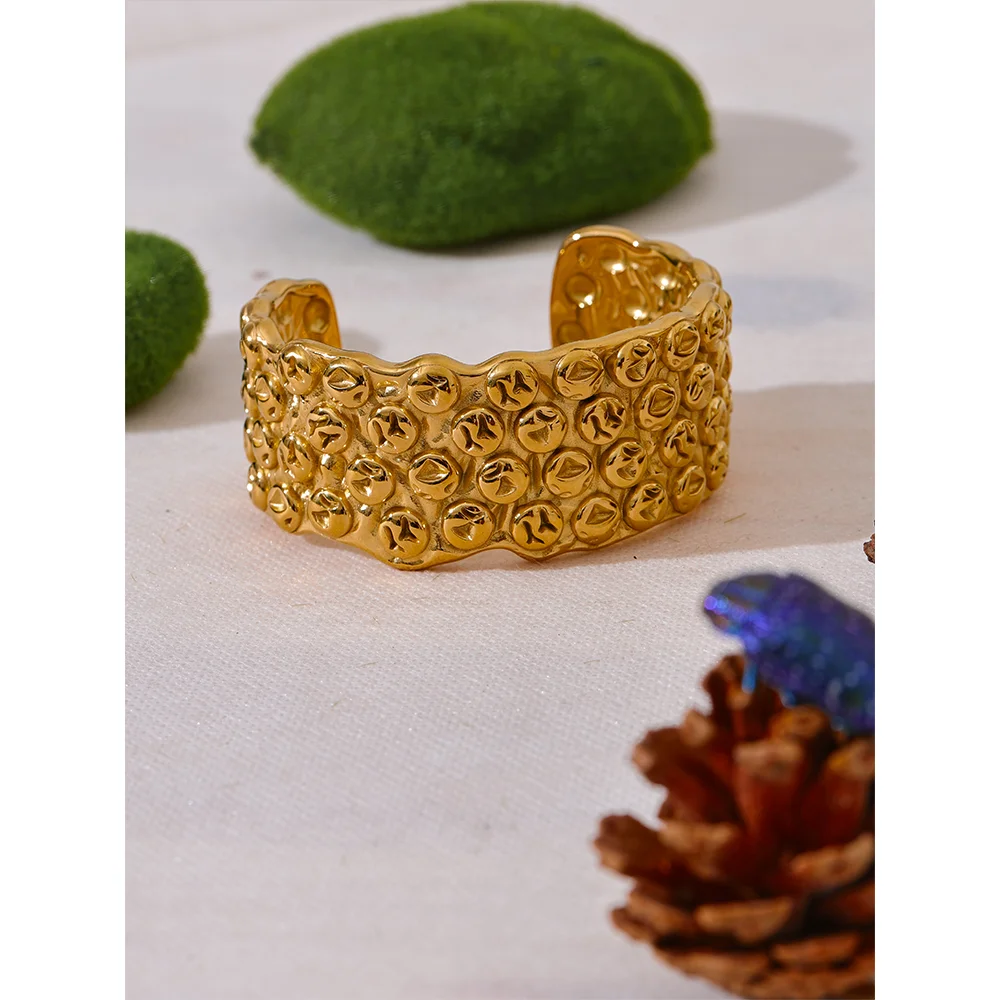 Gold cuff bracelet detail on stainless steel jewelry with smooth open design