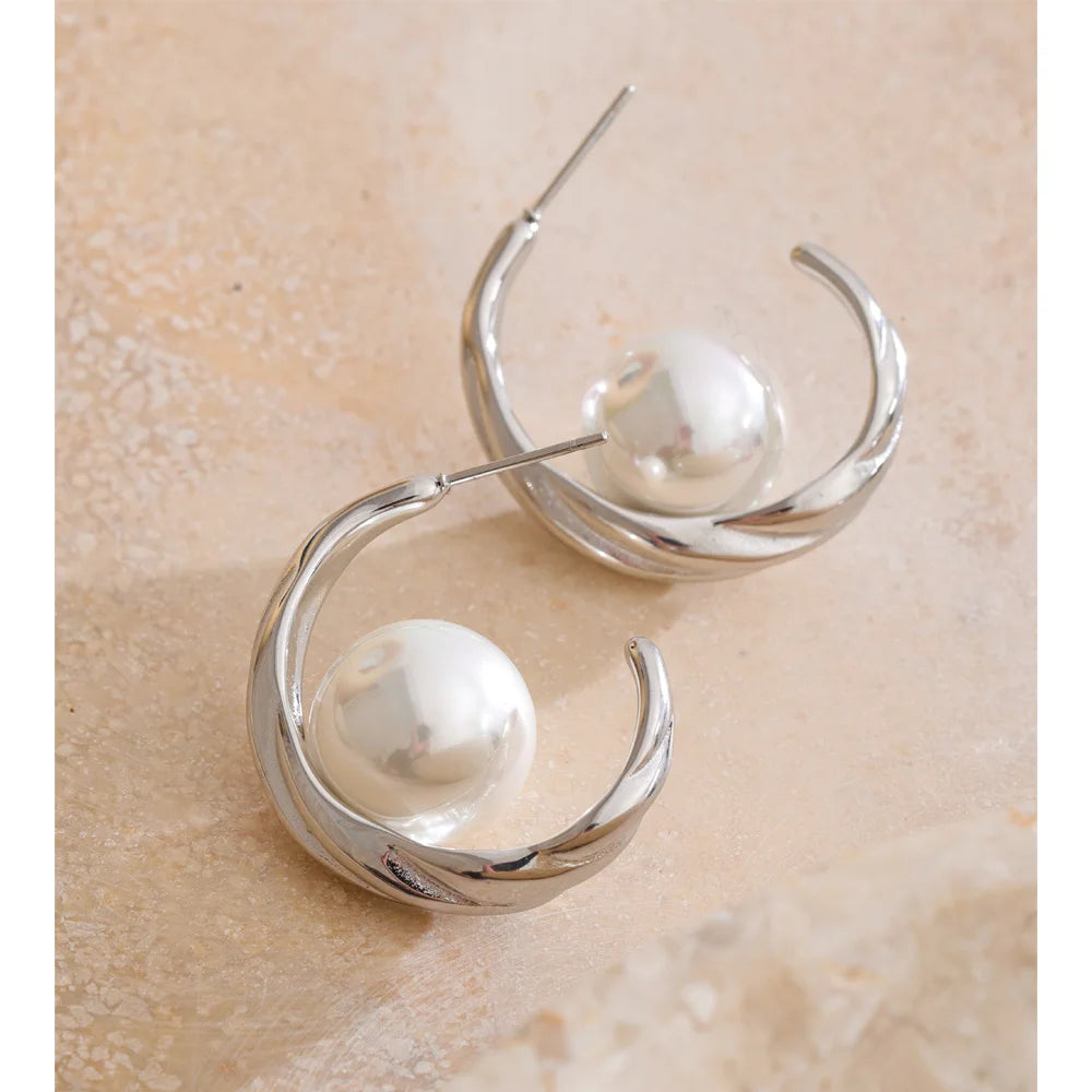 Close up of stainless steel earrings with pearl for party wear