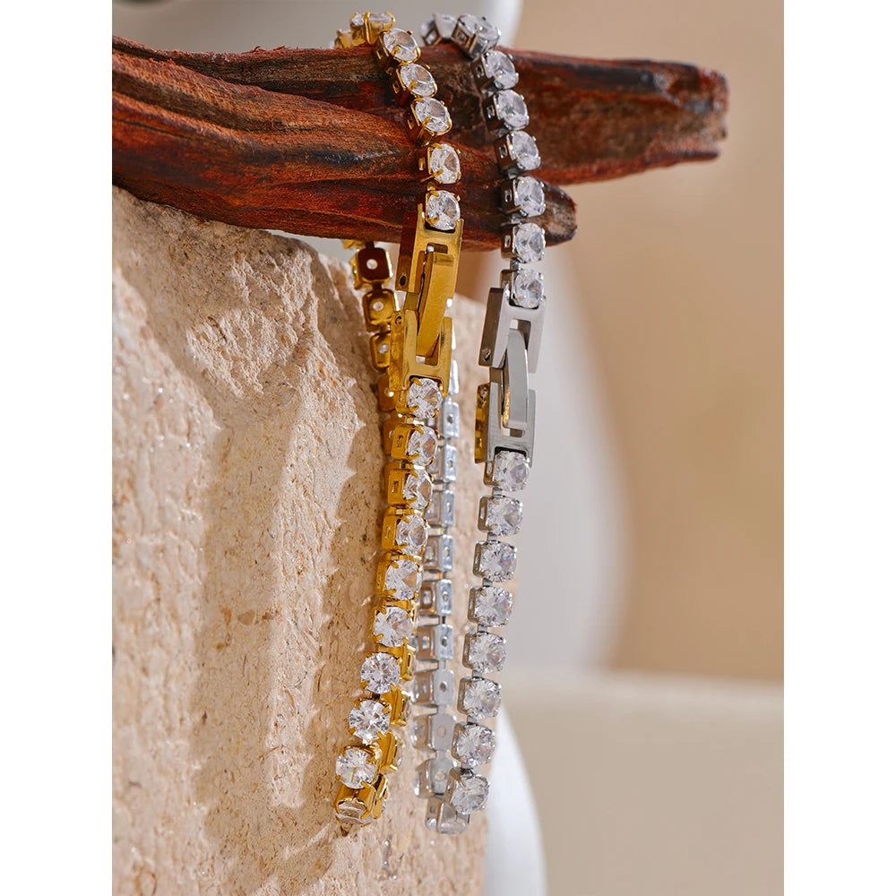 Chain bracelet layered beside cubic zirconia rings for a polished stack