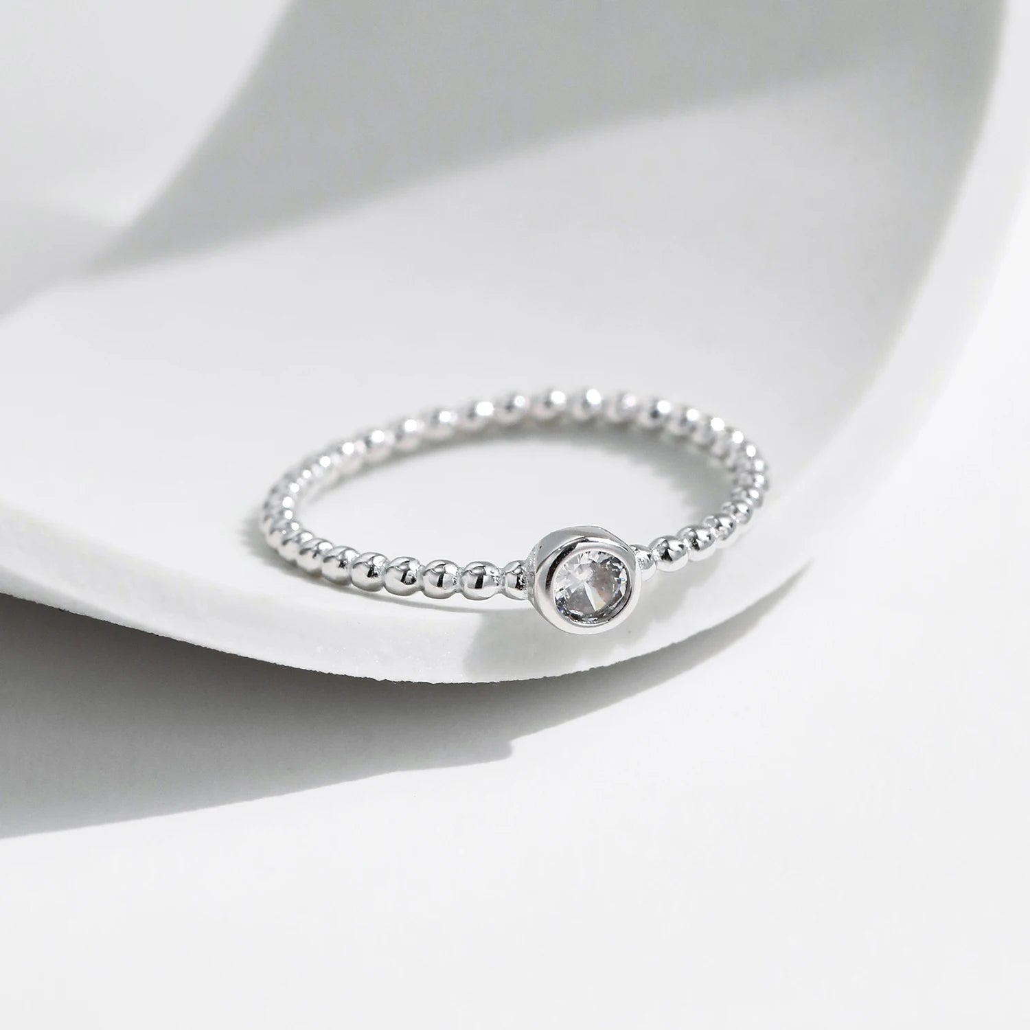 Modern ring stack using a bezel moissanite ring and matching silver set