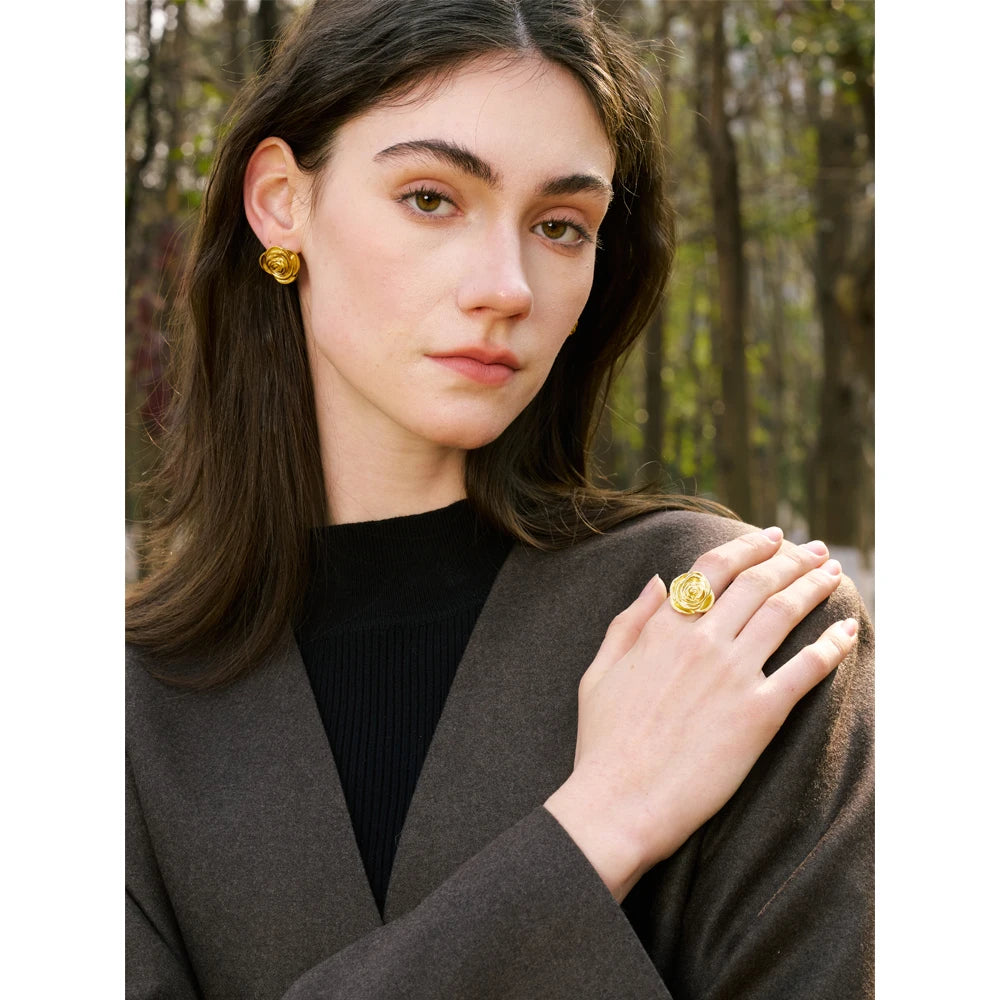 Wrist and hand shot pairing a gold ring with earrings earrings gold accents