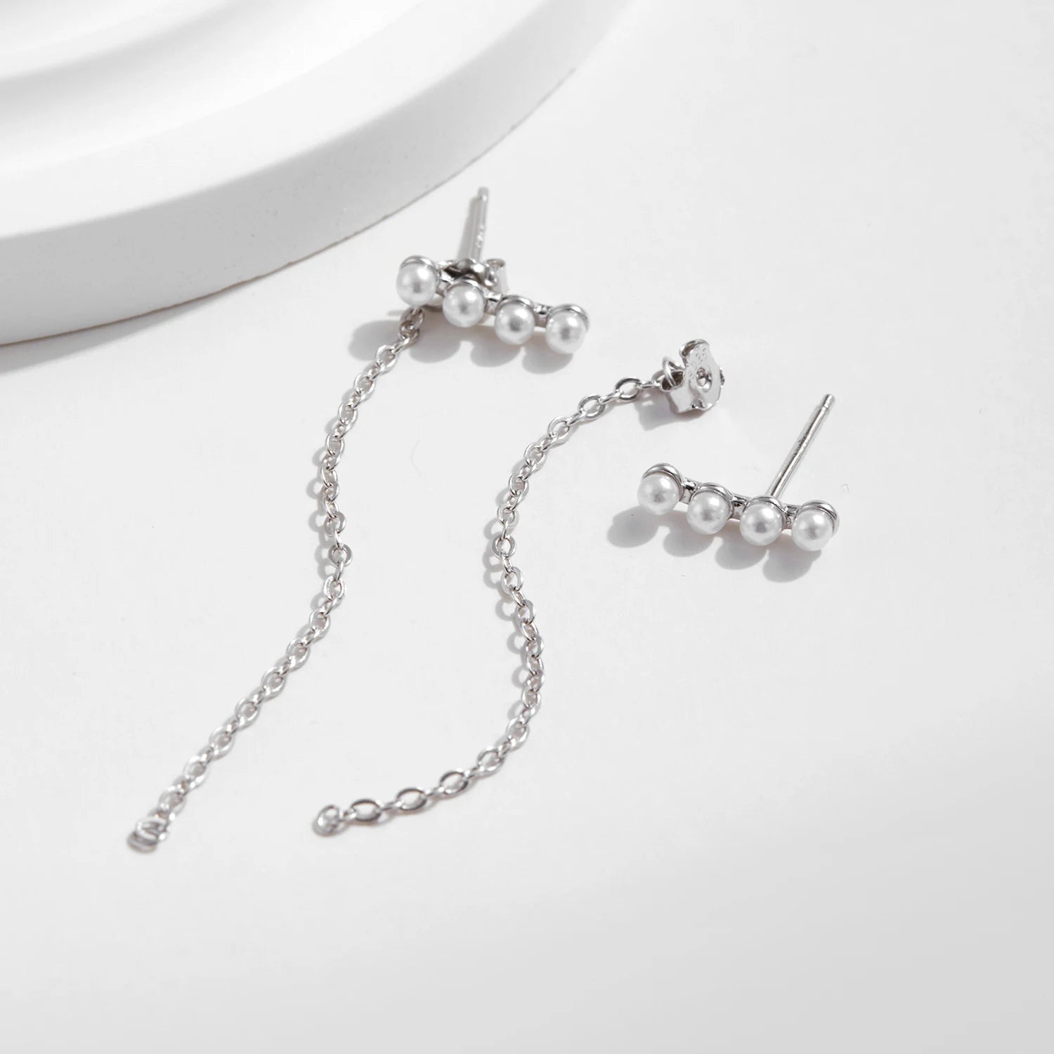 Elegant ear rings showcasing pearl drop earrings and geometric top