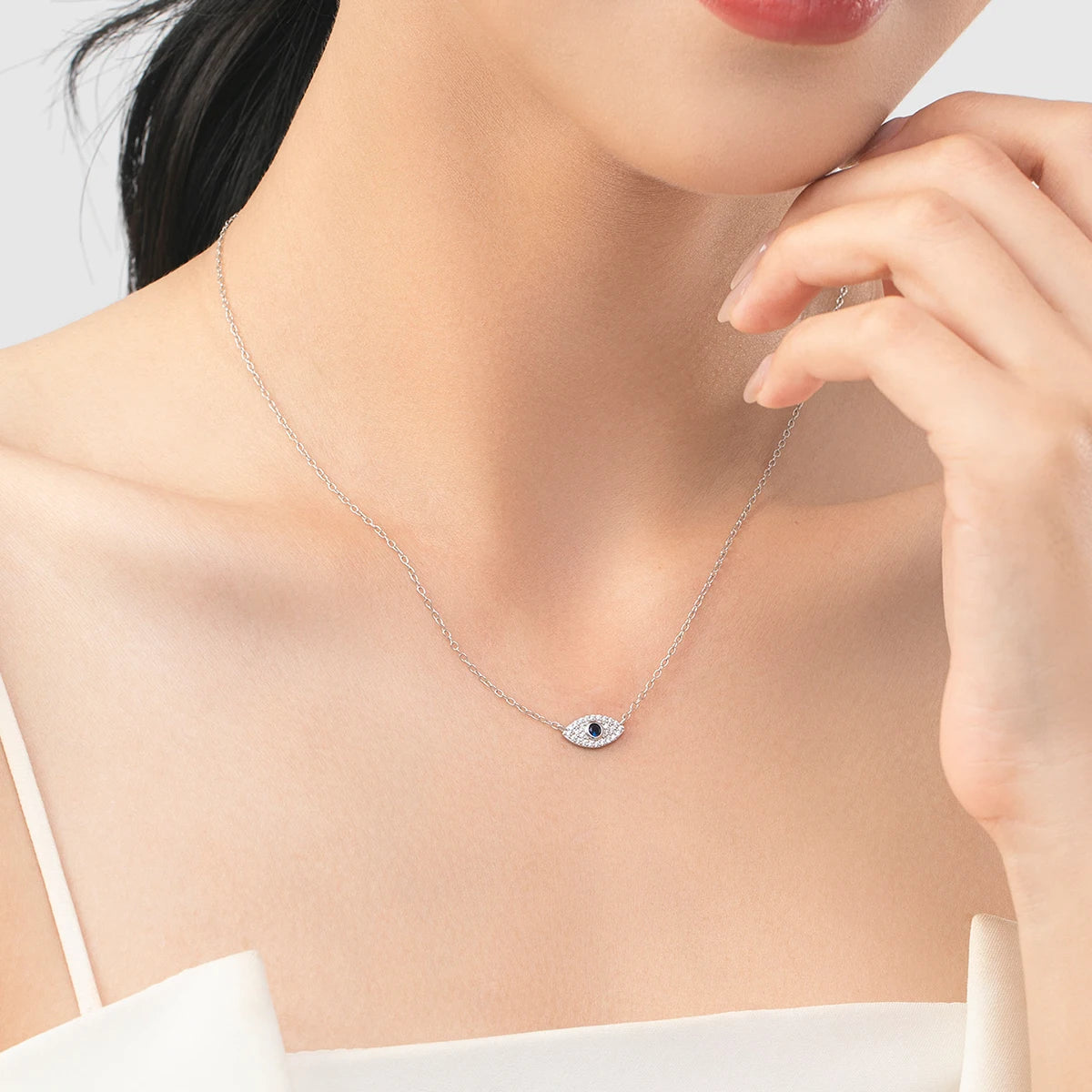 Silver jewelry display showing sterling silver necklace with blue eye accent