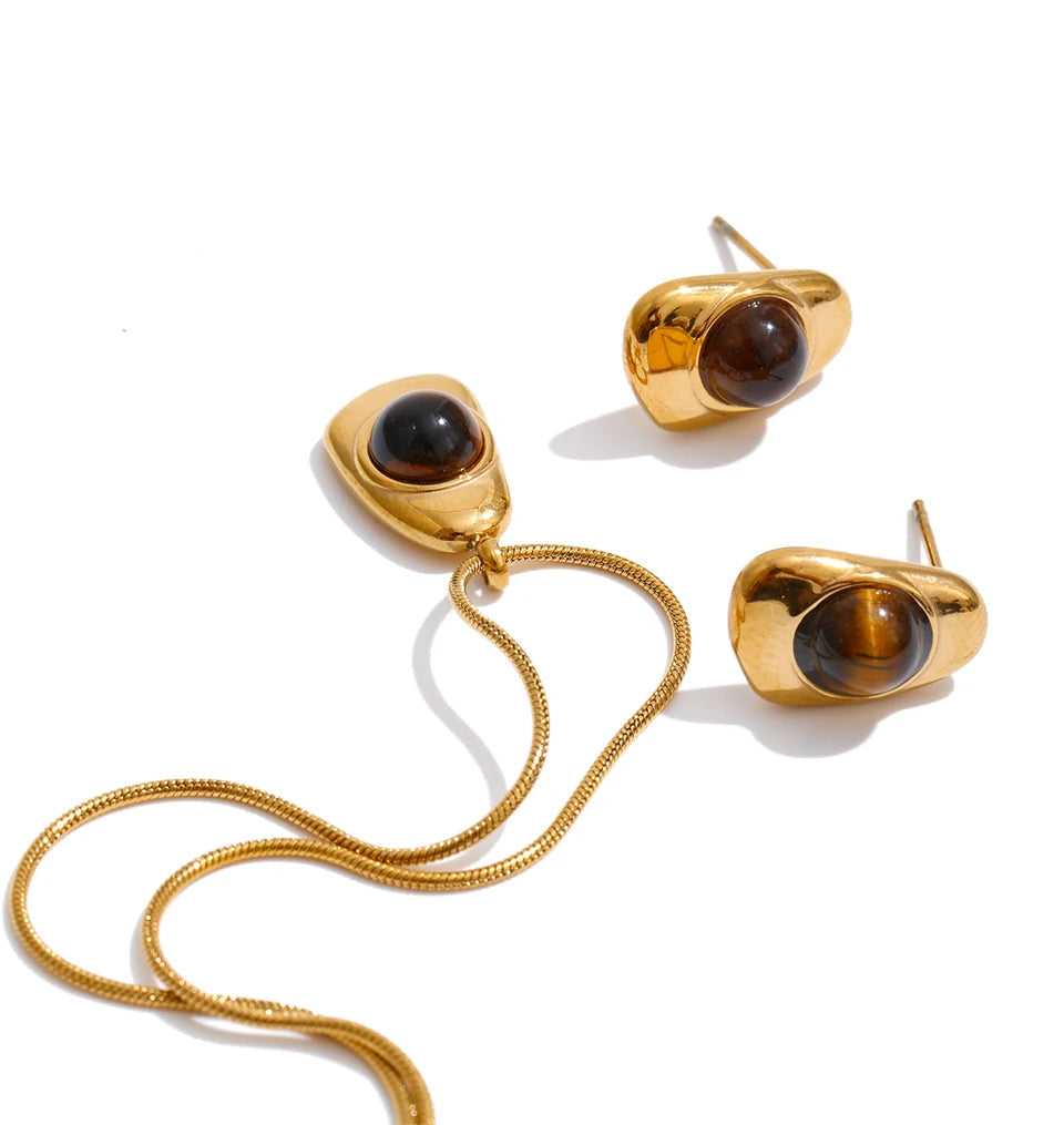 Soft light macro of pearl on a necklace aligned with tiger eye stone charm