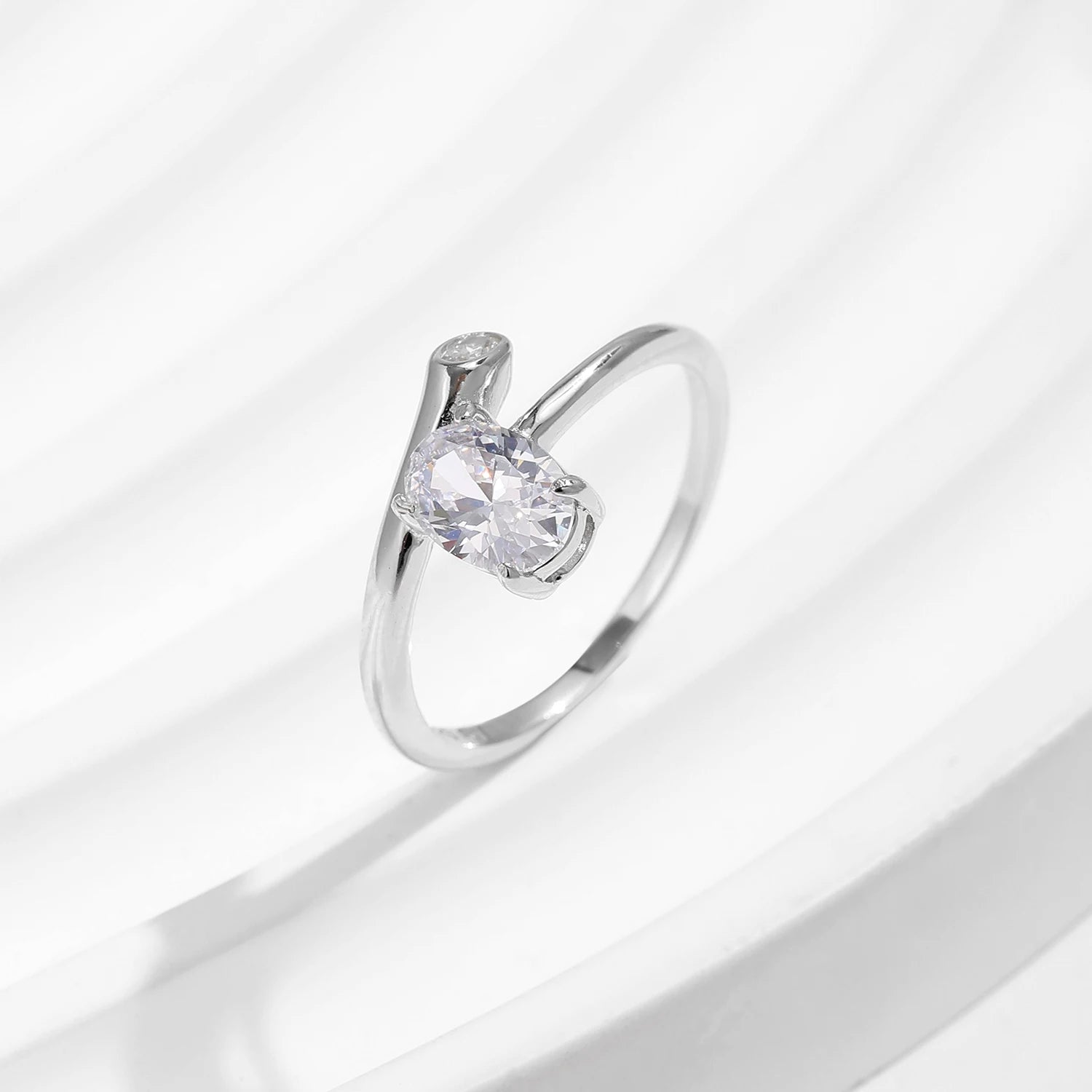 Irregular oval zirconia spark on sterling silver flowing band