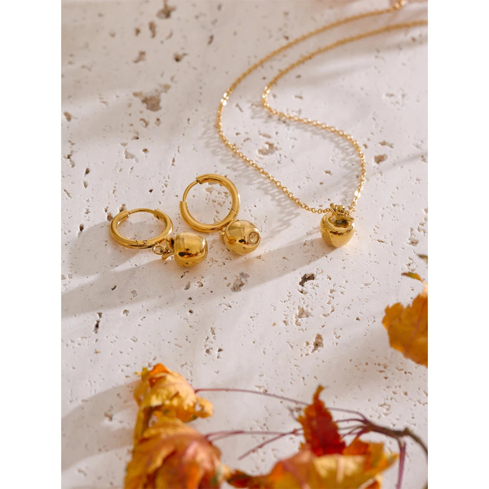 Elegant shot of earrings gold earrings next to a gold necklace