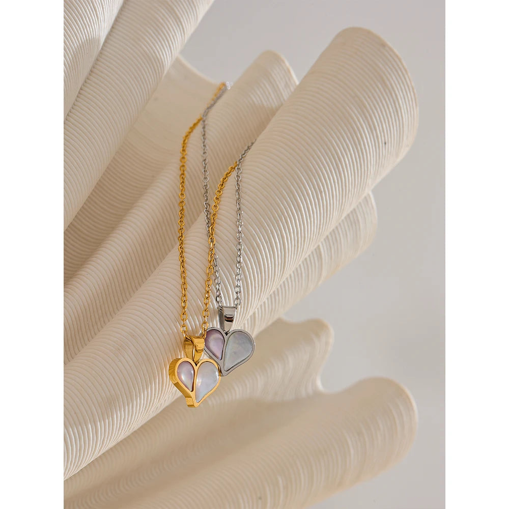 Layered shell necklace styling beneath a gold heart pendant