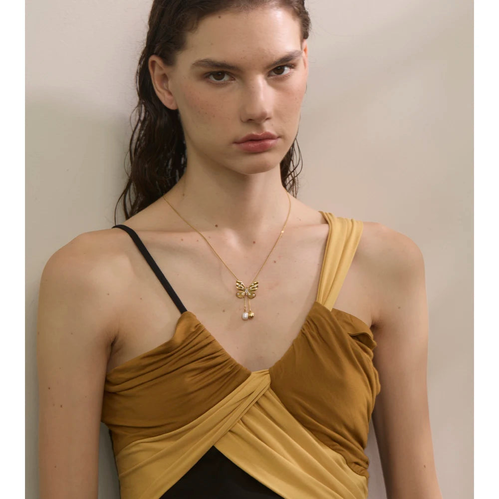 Close up of pearl on necklace with butterfly accent