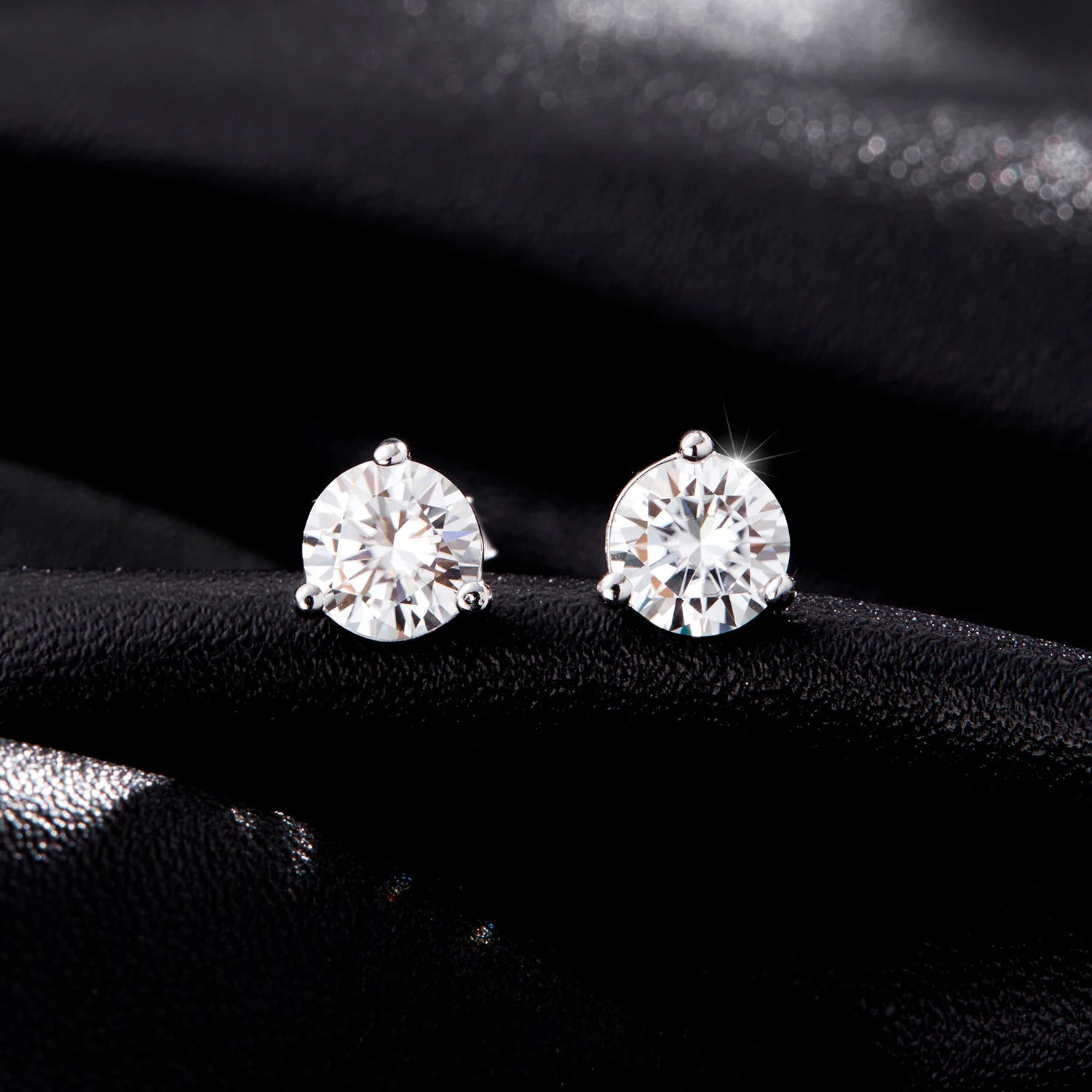 Refined ear rings featuring three prong mounted moissanite