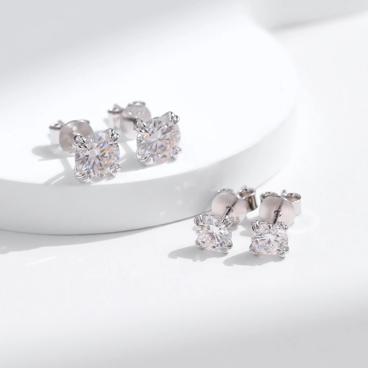 Stud earrings beside rings with moissanite for a coordinated set