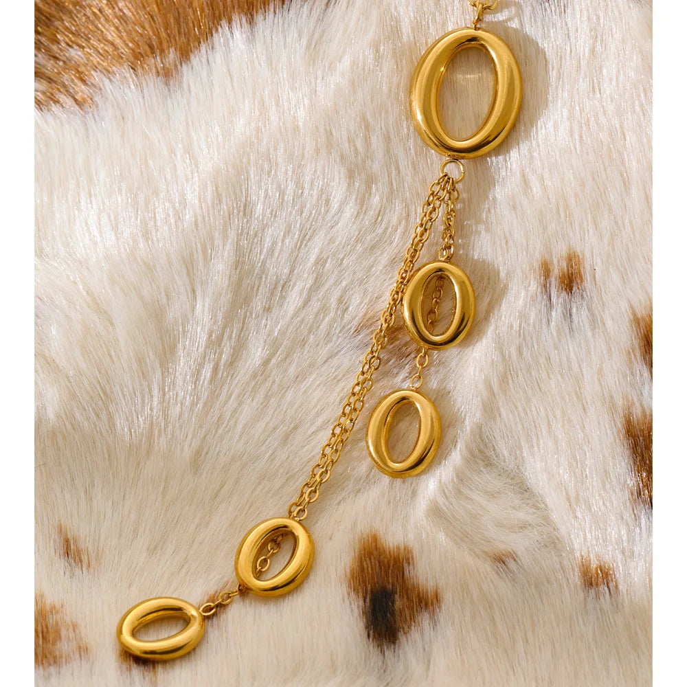 Close up of necklace charm with tassel detail and gold finish