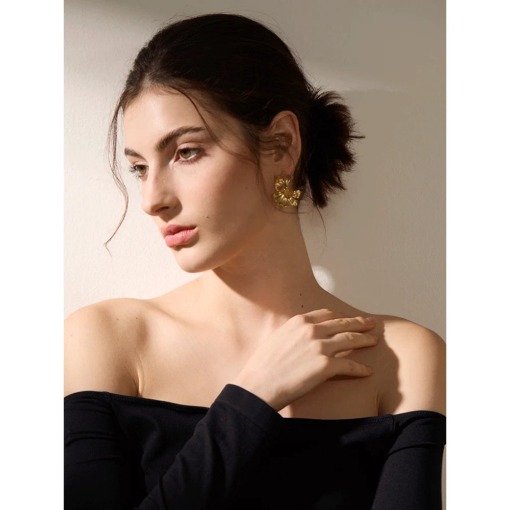 Earrings and gold statement with ginkgo leaf charm