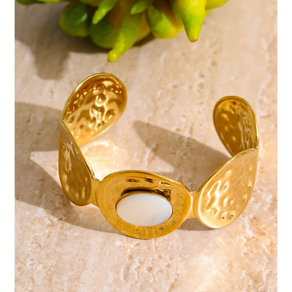 Close-up of hammered metal shell detail on gold plated cuff bangle