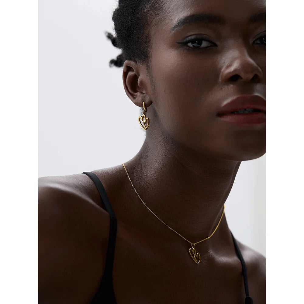 Necklace heart pendant paired with gold hoop earring style