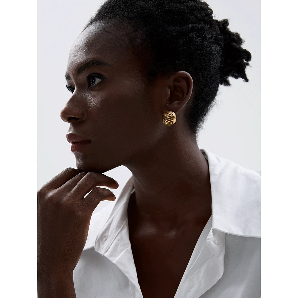 Close-up of hollow round earrings in polished stainless steel