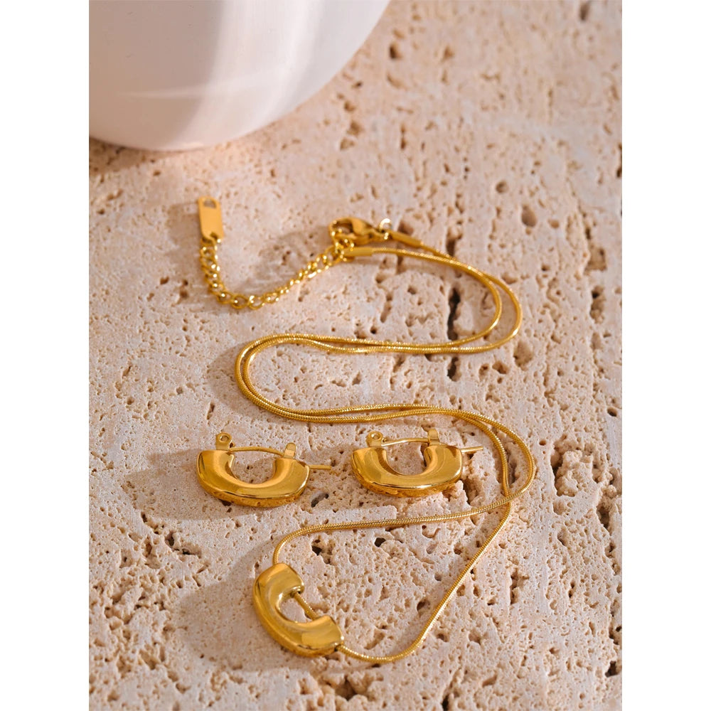 U shape pendant on a gold necklace paired with earrings gold earrings