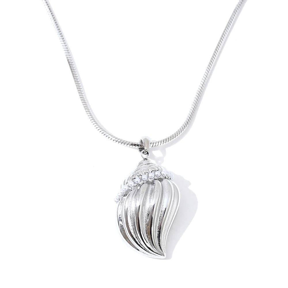 Clean background of necklace gold necklace styling with ocean conch centerpiece