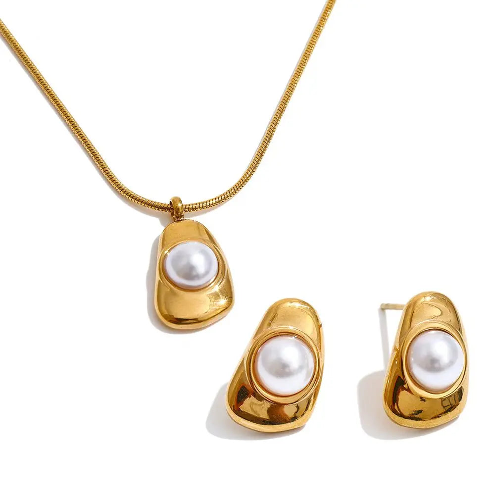 Clean background of pearl earrings alongside a necklace pearl necklace strand