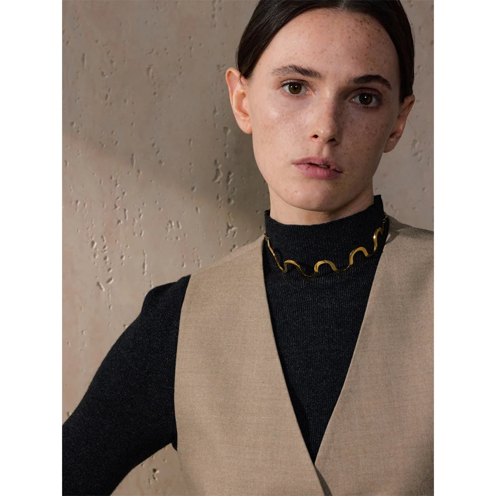 Gold jewelry choker with flowing wave design