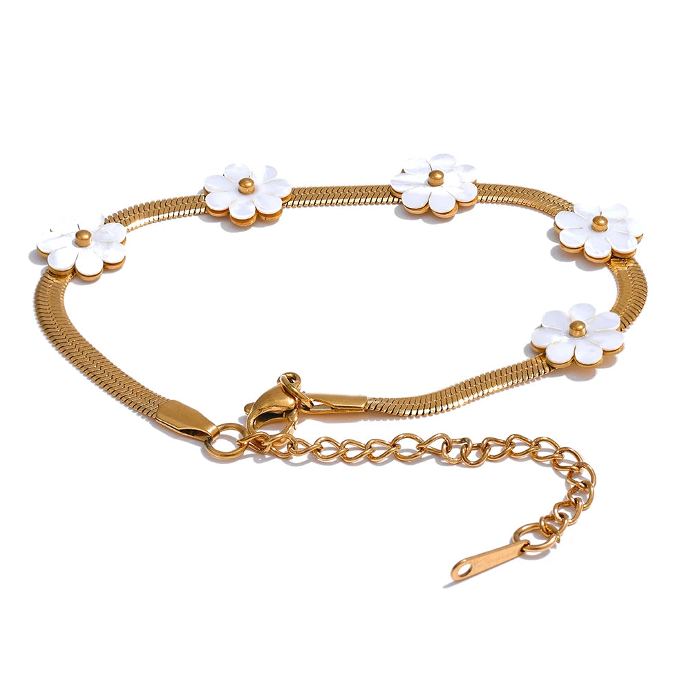 Seashell necklace charm complementing a gold bracelet bracelet