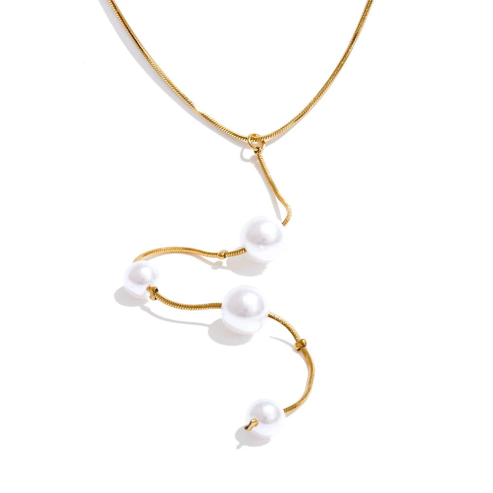 Close-up of pearl with necklace in polished gold tone