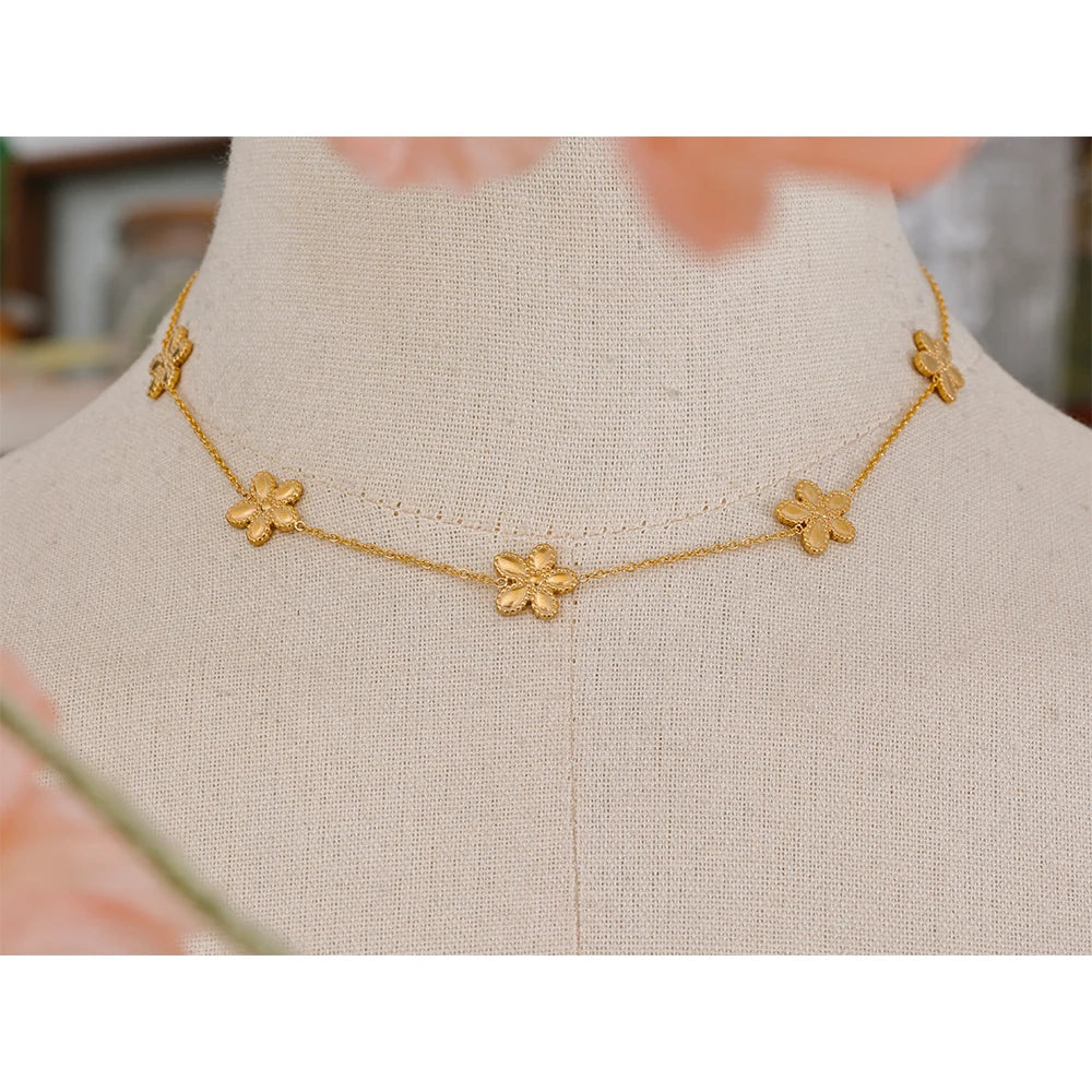 Close view of flower necklace detail in gold chain bracelet set