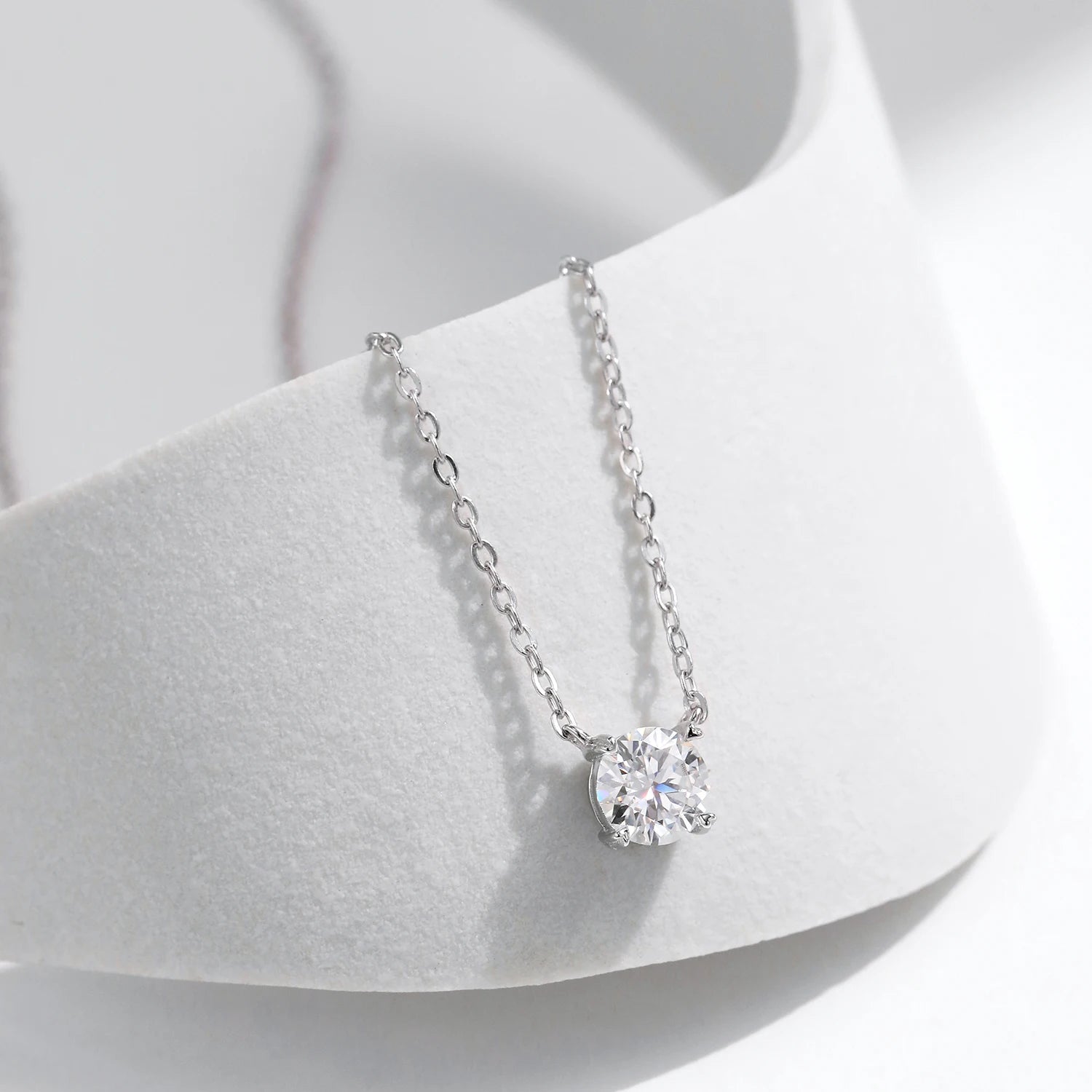 Sterling silver necklace holding a diamond pendant with moissanite diamond